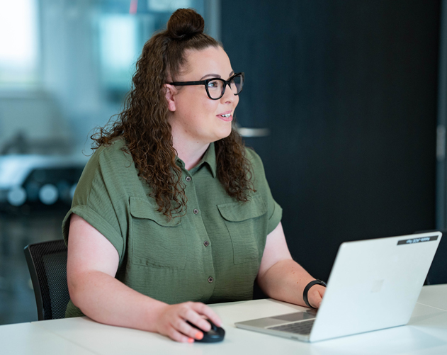 Woman sitting with a laptop on a desk